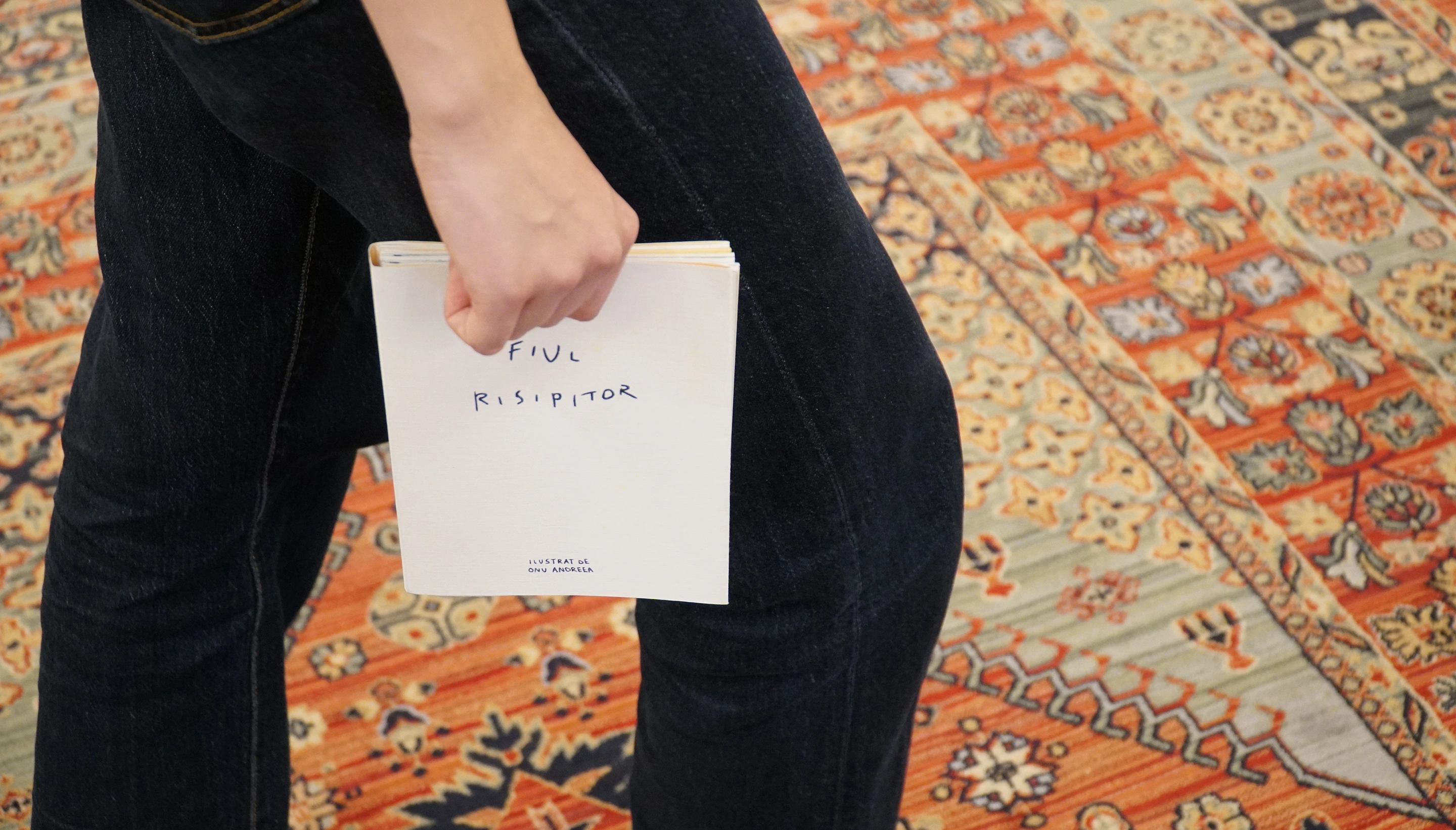Holding the finished Prodigal Son book above a patterned rug