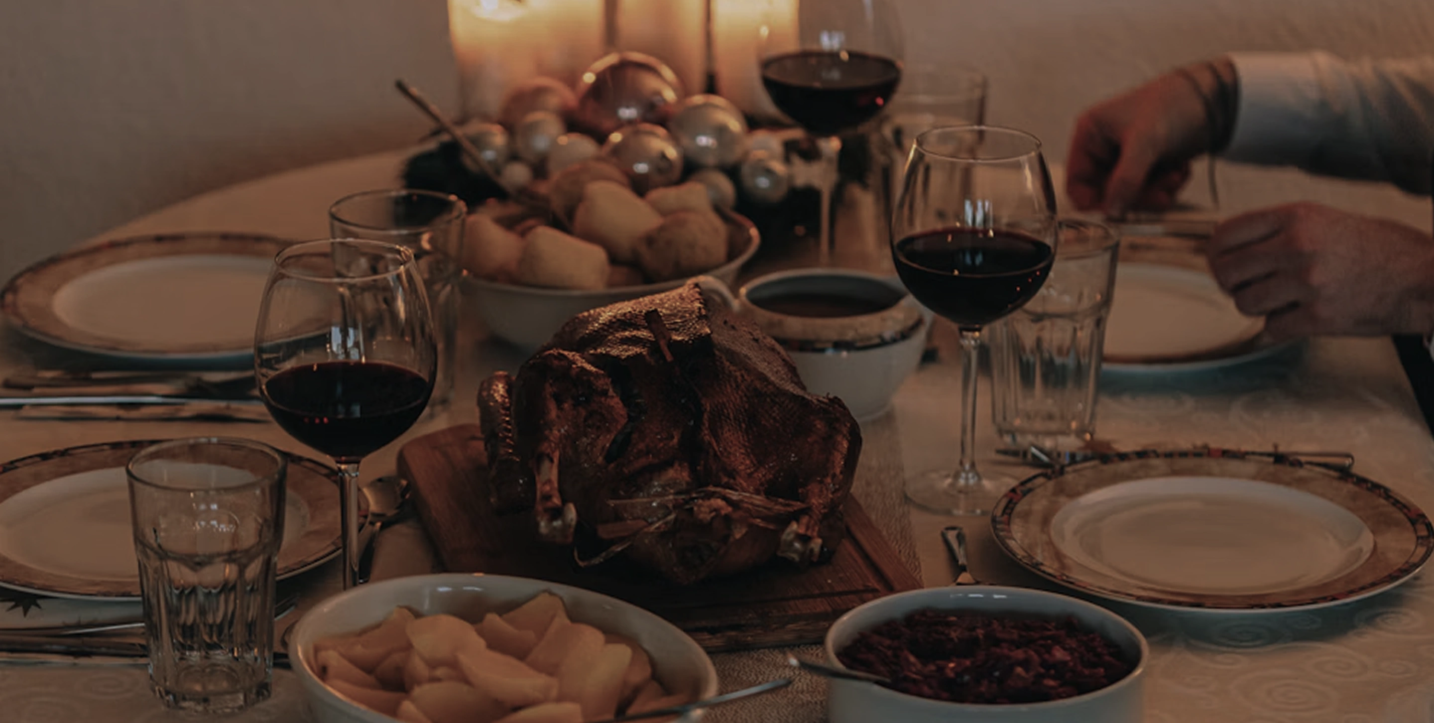 A candlelit dinner table with wine and traditional food