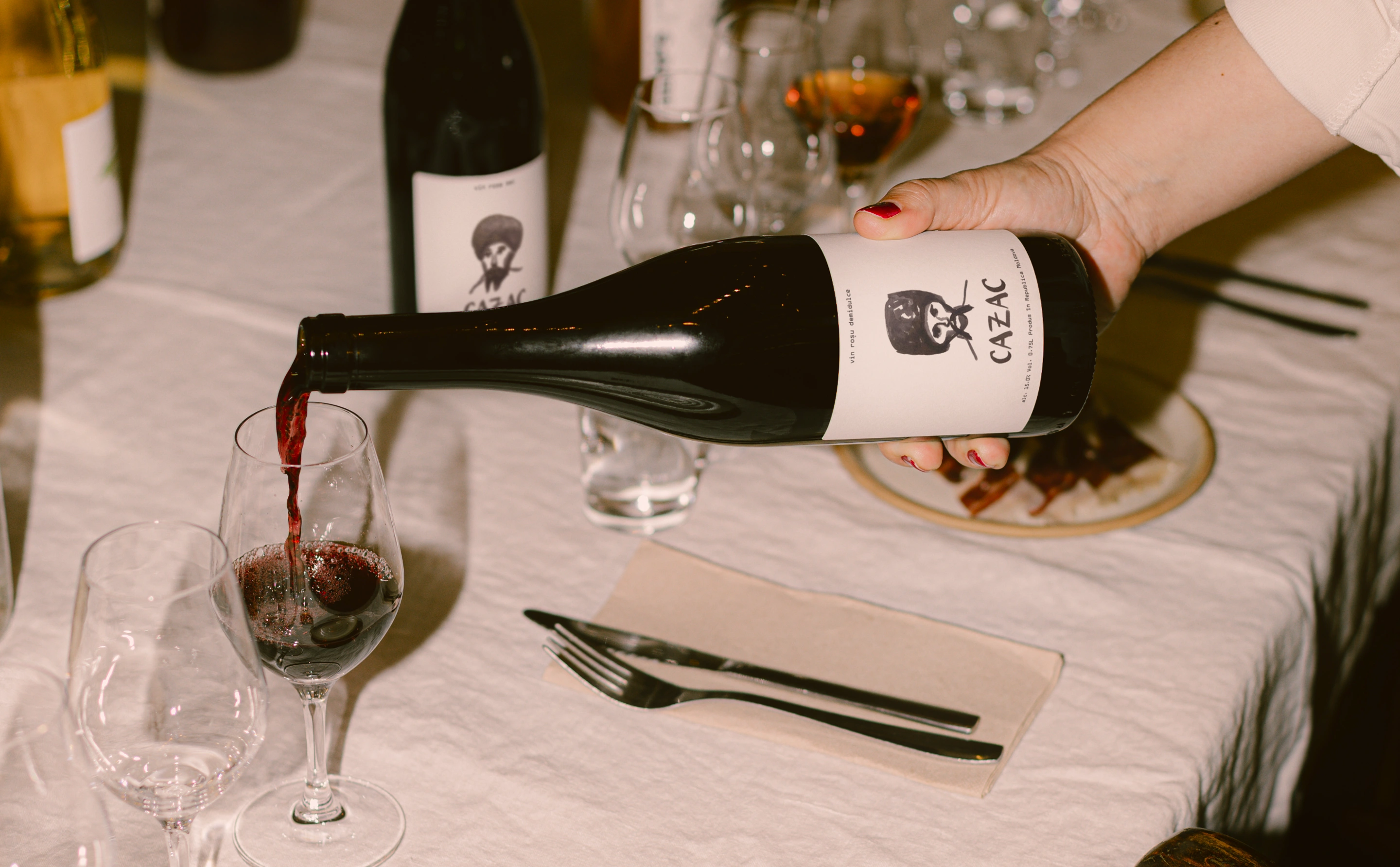 Pouring Cazac wine at a dinner table