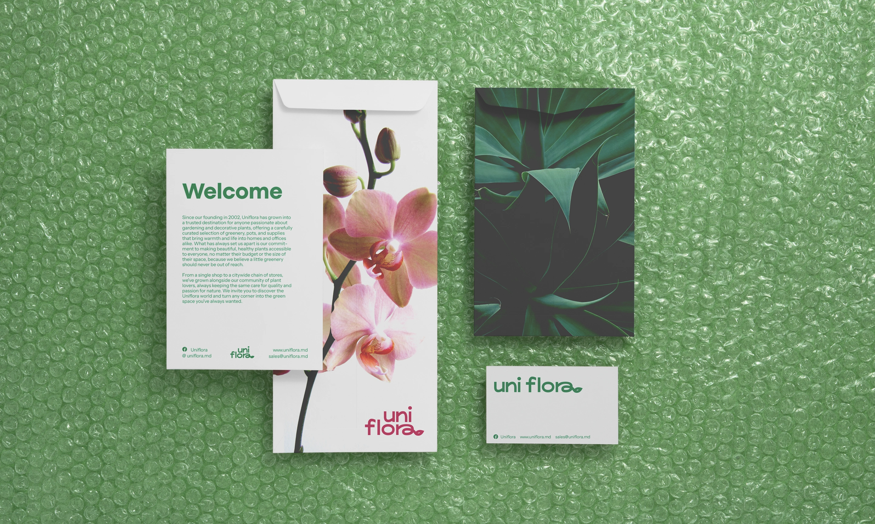Uniflora stationery, floral envelope, welcome card, and business card on green bubble wrap