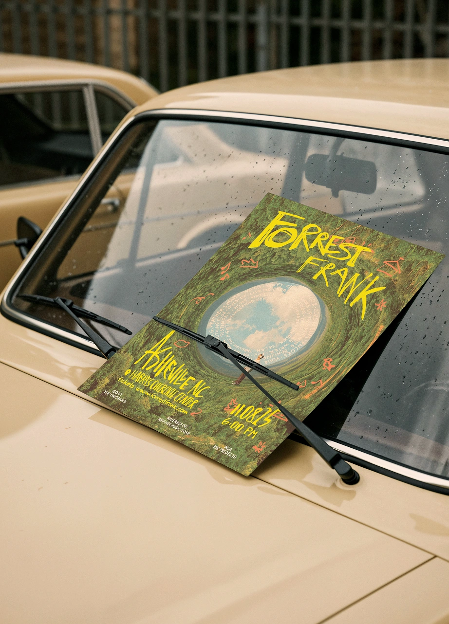 Asheville poster tucked under a yellow car's windscreen wiper